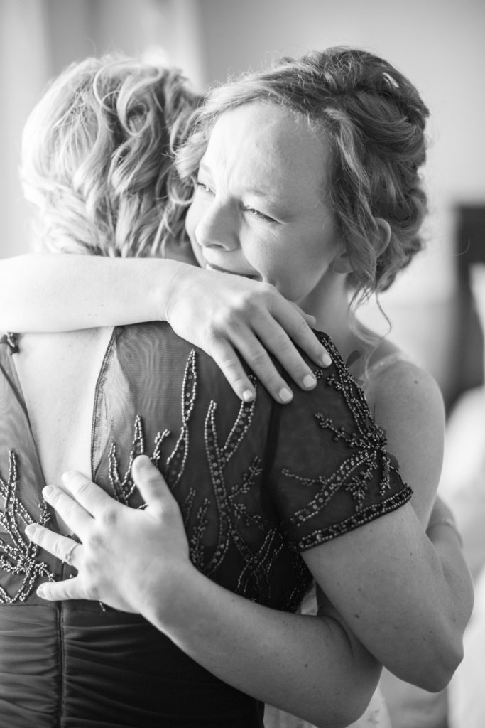 A bride hugs her mother and cries on her wedding day.