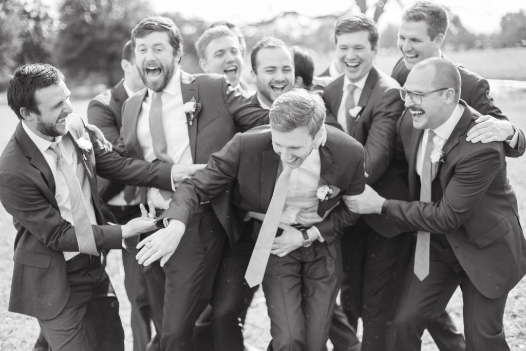 Groomsmen having a great time at a wedding.