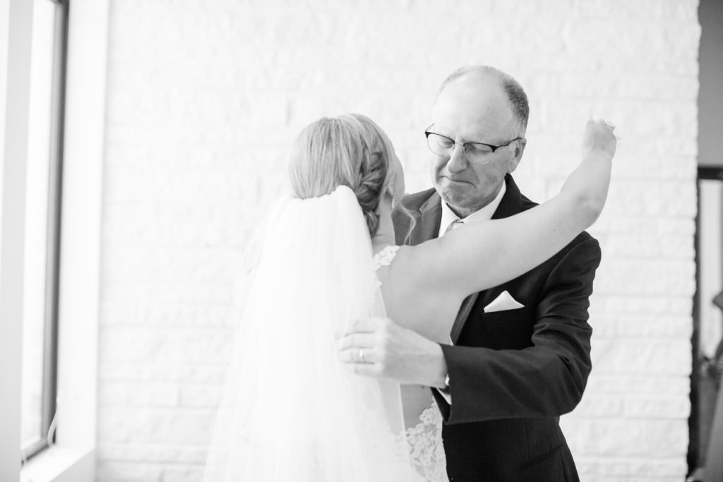 A bride hugs her dad on her wedding day as her dad cries.